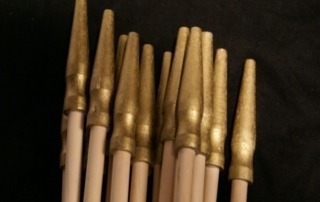Multiple custom wooden flag dowels laid out in rows, manufactured for high-volume orders and commercial use.